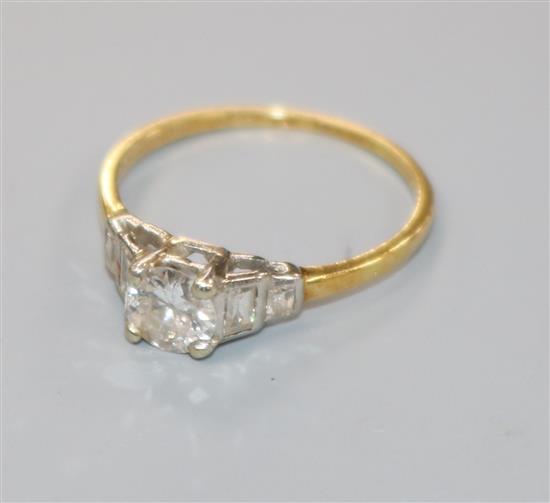 A 1940s 18ct gold, platinum and single stone diamond ring with graduated baguette cut diamond set shoulders, size I.